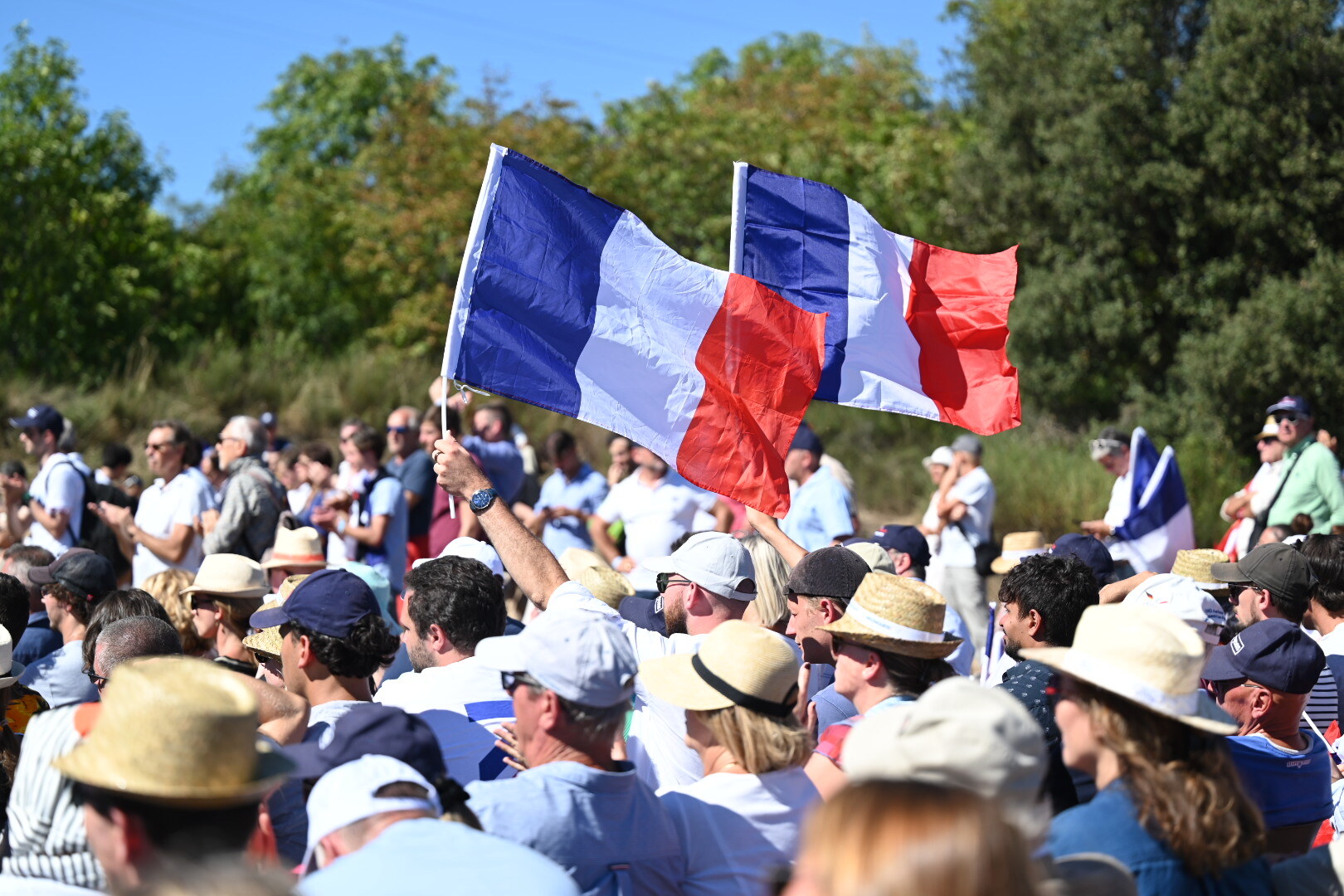 Des soutiens de Reconquête! brandissent des drapeaux français lors d’un rassemblement