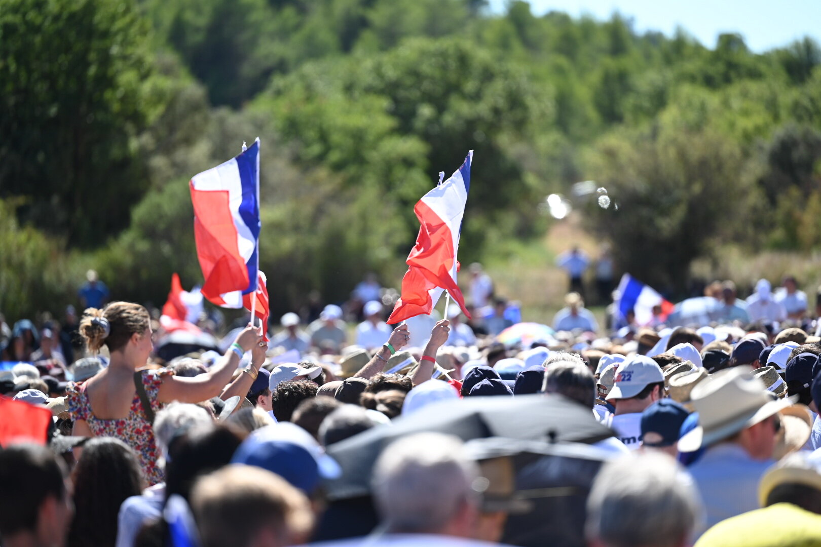 Foule de soutiens de Reconquête brandissant des drapeaux tricolores en plein air