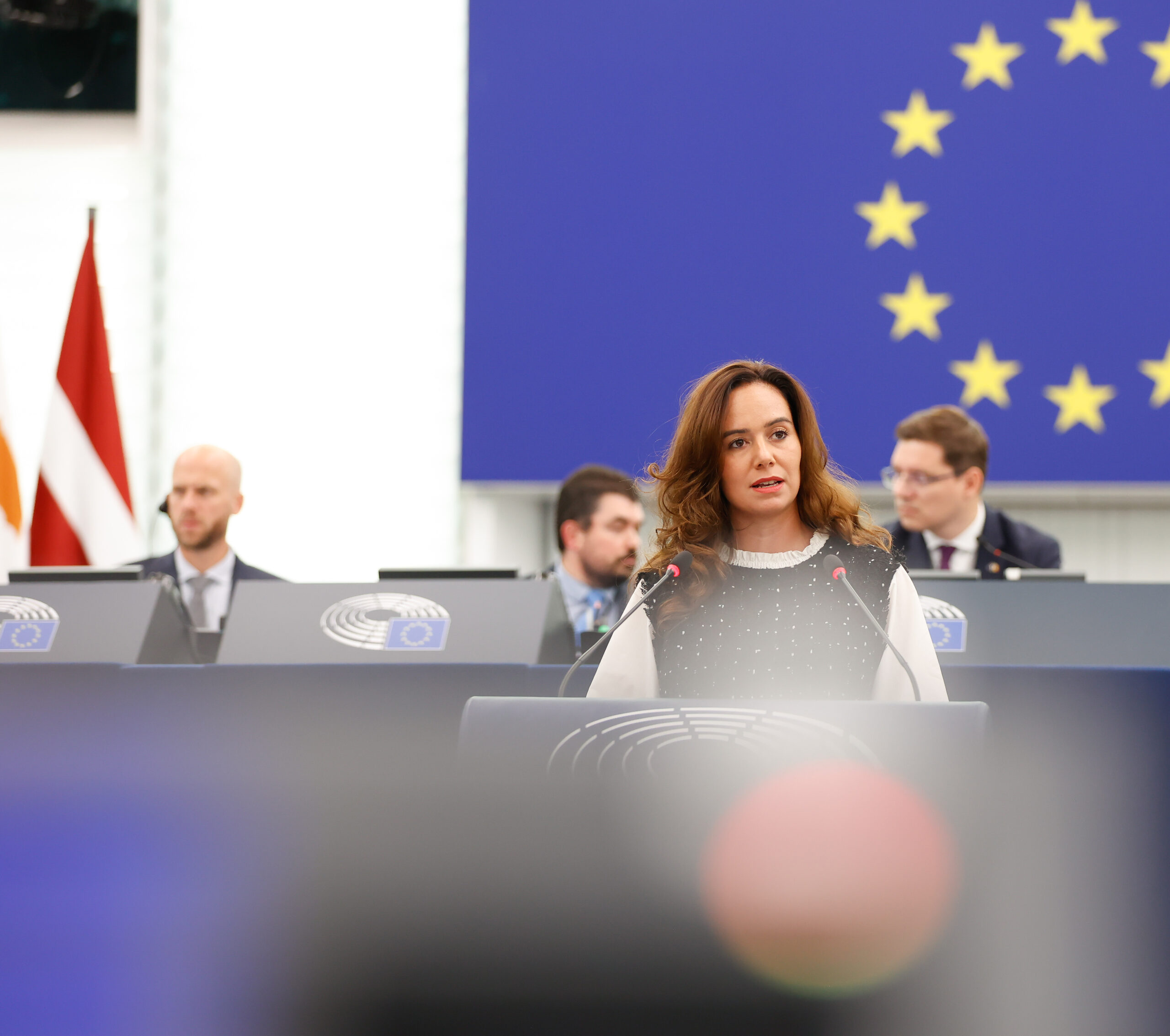 Sarah Knafo à la tribune du Parlement européen, devant le drapeau européen